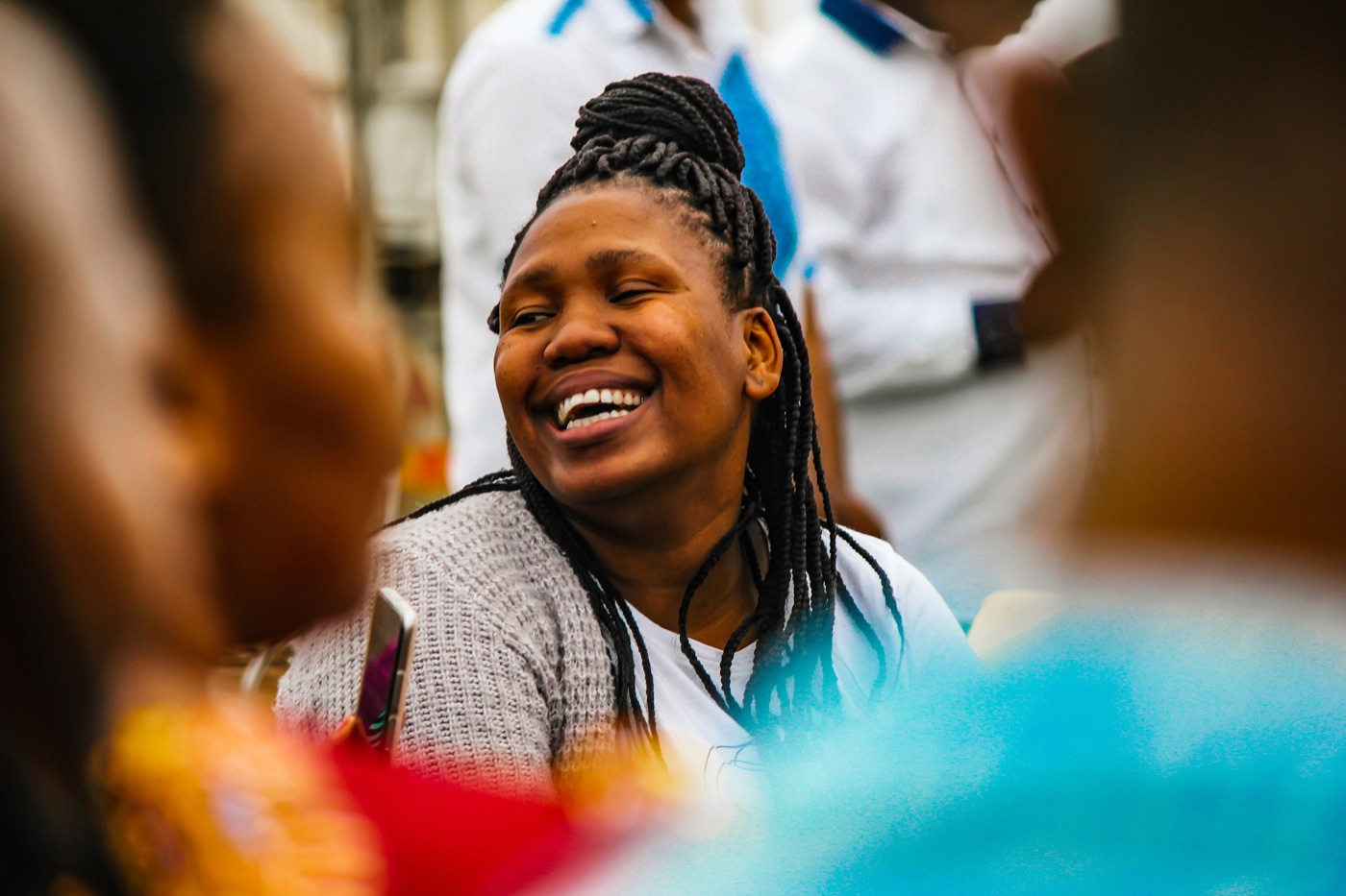 A woman laughing with people gathered around her